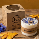 Beauty Scents Large Candle With Wild Flowers next to its box on a wooden table