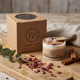 Beauty Scents Small Candles WIth Rose Petals next toits branded box on the wooden table