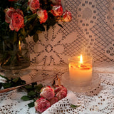 Candle with flowers on a lace tablecloth