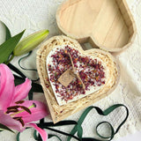 Detailed view of wooden heart box and rose petal candle, perfect gift