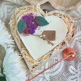 Top view of heart candle with lilac details in a wooden gift box
