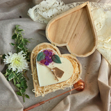 Handmade heart candle decorated with lilac flowers, set in rustic wooden box