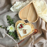 Top view of heart candle with red berry details in a wooden gift box