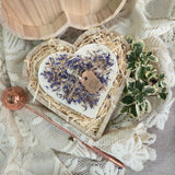 Handmade heart candle decorated with wild flowers in rustic wooden box