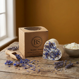 Heart-shaped candle with lavender on a wooden surface next to a box labeled 'BS beauty scents'.