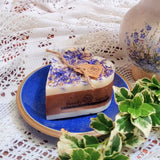 Heart-shaped candle with lavender on a blue plate on a lace tablecloth